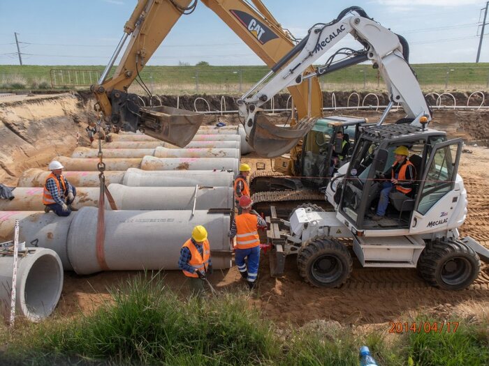 Brygada ZIĘBUD i koparki podczas montażu prefabrykowanych elementów betonowej kanalizacji